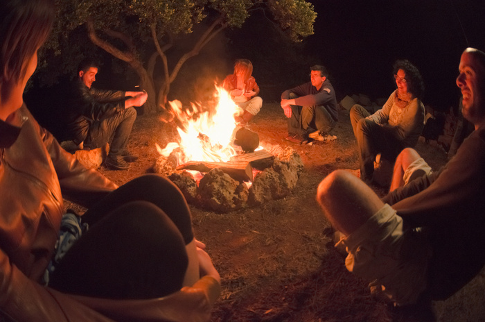 Group gathered around campfire in the woods